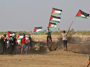 Palestinian demonstrators wave the national flag during clashes between Palestinian protesters and Israeli forces. (AFP/ File Photo)
