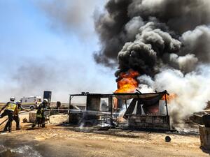 Firefighters from the Syrian Civil Defence, also known as the "White Helmets", extinguish a fire at a vehicle gathering point for fleeing civilians, which was hit by reported government forces' bombardment, in Maar Shurin . (AFP/ File Photo)