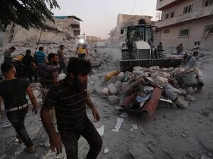 Members of the Syrian Civil Defence (White Helmets) clear debris during their search for survivors following a reported airstrike