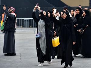 Saudi women take photographs with their mobile phones pior to the 2018 Saudia Ad Diriyah E-Prix Formula E Championship in Riyadh. (AFP /FAYEZ NURELDINE)