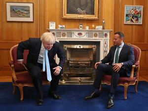 Britain's Prime Minister Boris Johnson (L) rises from his chair after posing for a photograph with Irish Prime Minister Leo Varadkar (R) (AFP)