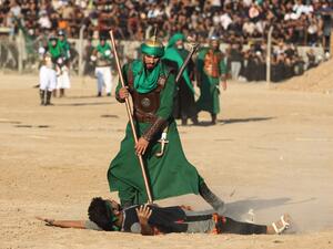 Iraqi Shiite Muslims costumes re-enact events of Ashura, in Baghdad's predominantly Shiite Sadr City (AFP)