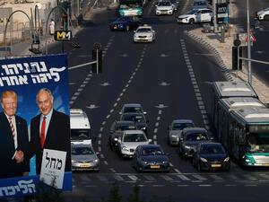 Traffic drives past an Israeli election billboard for the Likud party, showing US President Donald Trump (L) shaking hands with Likud chairman and Prime Minister Benjamin Netanyahu in Jerusalem AHMAD GHARABLI / AFP