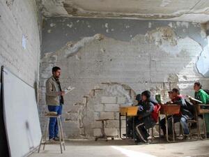 Children attend a class in a school in Idlib that was partially destroyed [AFP/Getty]
