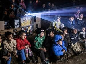 Ali Noureddine's photo captures refugee children watching a movie in a kids-only cinema at the Eidomeni refugee camp at the Greek-Macedonian border. (Photo by Ali Noureddine, courtesy of Beirut Image Festival)