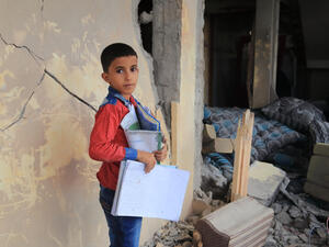 A Yemeni child stands in the middle of his destroyed house because of a rocket. (Shutterstock/ File Photo)