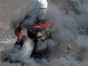 A Palestinian protester burns tyres during clashes with Israeli security forces at the entrance of the West Bank city of Ramallah close to the Jewish settlement of Beit El, following a demonstration to show solidarity with Palestinian prisoners held in Israeli jails on October 1, 2019. (ABBAS MOMANI / AFP)