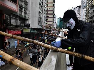 A protester uses bamboo scaffolding to make a road block as others take part in a march through the Tsim Sha Tsui area of Hong Kong on October 6, 2019. (AFP/ File Photo)