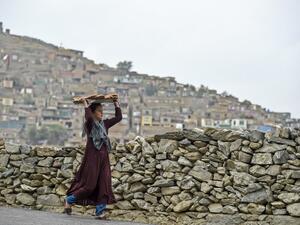 A young girl carries bread on a tray over her head at a hillside overlooking Kabul on October 6, 2019. (WAKIL KOHSAR / AFP)