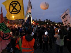 Protesters dance on the Pont au Change bridge as they take part in a demonstration called by climate change activist group Extinction Rebellion, on October 7, 2019 in front of the Conciergerie in Paris. (AFP/ File Photo)
