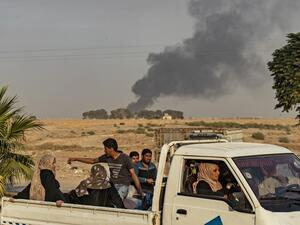 Civilians ride a pickup truck as smoke billows following Turkish bombardment on Syria's northeastern town of Ras al-Ain in the Hasakeh province along the Turkish border on October 9, 2019. (AFP/ File Photo)
