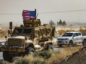 In this file photo taken on October 6, 2019 a US soldier sits atop an armoured vehicle during a demonstration by Syrian Kurds against Turkish threats next to a base for the US-led international coalition on the outskirts of Ras al-Ain town in Syria's Hasakeh province near the Turkish border. (AFP/ File Photo)