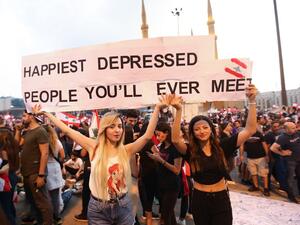 Lebanese demonstrators carry a placard as they take part in a rally in the capital Beirut's downtown district on October 20, 2019. (AFP/ File Photo)