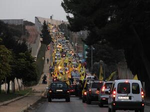 Supporters of the Shiite Hezbollah movement drive in a convoy in support of its leader Hassan Nasrallah's speech, in the area of Fatima's Gate in Kfar Kila on the Lebanese border with Israel on October 25, 2019. (AFP)