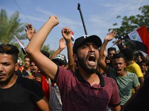 Iraqi protesters chant during an anti-government demonstration outside the Najaf governorate headquarters in the central shrine city, on October 27, 2019. Iraq's capital and country's south have been rocked by a second wave of demonstrations with protesters digging in despite tear gas, curfews and violence that has left over 60 dead. AFP
