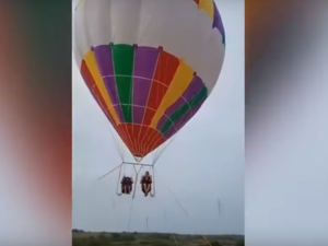 The footage shows the mother and her son sitting side by side and secured with harnesses beneath the large helium balloon. (Video Screenshot)
