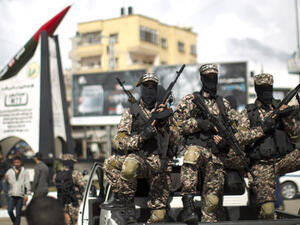 Members of Hamas's military wing pose in front of a M-75 rocket in Gaza. (AFP/ File Photo)