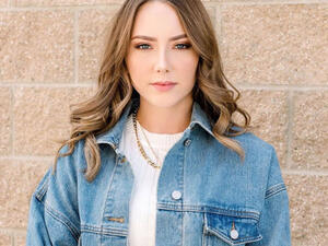 Hailie covered up in a thigh-length forest green dress which was covered in a white and black plaid print. 