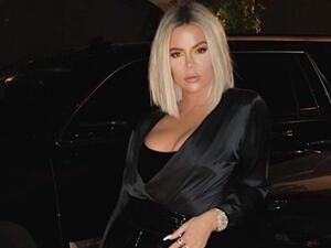 Kardashian can be seen taking the picture on her phone as she poses in a hallway.