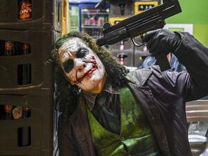 Venezuelan migrant Johnny Tales (R), who makes a living imitating the comicbook and film character "The Joker", poses at a convenience store in Medellin, on October 29, 2019. JOAQUIN SARMIENTO / AFP
