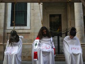 Lebanese protesters stage a mock hanging in a symbolic performance against sectarianism (C), Lebanon's 1975-90 civil war (R) and corruption during ongoing anti-government demonstrations in Downtown Beirut on November 3, 2019. (Patrick BAZ / AFP)