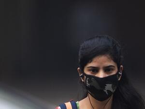 A woman wearing a protective face mask walks along a street in smoggy conditions in New Delhi on November 4, 2019. Millions of people in India's capital started the week on November 4 choking through "eye-burning" smog, with schools closed, cars taken off the road and construction halted. Jewel SAMAD / AFP