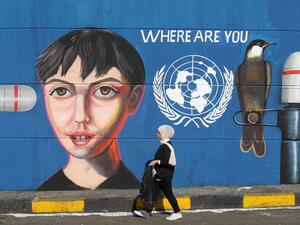 An Iraqi woman walks along a wall covered with a mural painting during an anti-government demonstration in the capital Baghdad's Tahrir square on November 4, 2019. (AFP/ File Photo)