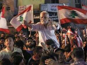 Lebanese protesters chant slogans and wave their country's national flag during ongoing anti-government demonstrations in Lebanon (AFP)