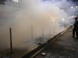 A bystander records footage with his mobile phone as firemen extinguish a burning barricade after a protest in the Tuen Mun district of Hong Kong on November 10, 2019. The international finance hub has been upended by five months of huge and increasingly violent rallies, but Beijing has refused to give in to most of the movement's demands. Philip FONG / AFP