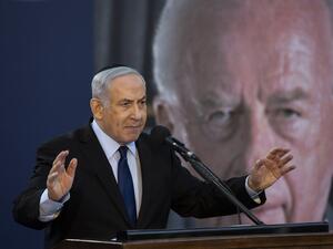 Israeli Prime Minister Benjamin Netanyahu speaks during a state memorial ceremony for former Israeli prime minister Yitzhak Rabin (backround) and his wife Leah, at Mount Herzl in Jerusalem on November 10, 2019.  (HEIDI LEVINE / POOL / AFP)