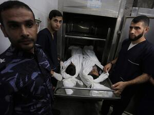 Palestinian police and morgue workers show the bodies of two of six members of the same family killed in an Israeli airstrike, at a morgue in central Gaza Strip's Deir al-Balah on November 14, 2019. Six members of the same family were killed in an Israeli airstrike on the southern Gaza Strip, the health ministry of the coastal Palestinian enclave said on November 14. The deaths bring the toll from Israeli strikes targeting Islamic Jihad militant sites to 32 since November 12, while 350 rockets have been fir