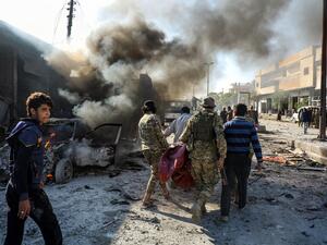 Pro-Turkish Syrian fighters carry away remains of the victims of a car bomb explosion at the industrial zone in the northern Syrian town of Tal Abyad, on the border with Turkey on November 23, 2019.  (AFP/ File Photo)