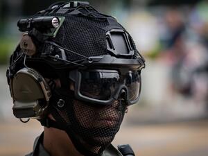 A riot police officer monitors people (not pictured) gathered in the street in support of pro-democracy protesters during a lunch break rally in the Kowloon Bay area in Hong Kong (AFP)