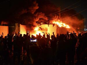 Iraqi demonstrators gather as flames start consuming Iran's consulate in the southern Iraqi Shiite holy city of Najaf on November 27, 2019, two months into the country's most serious social crisis in decades. Haidar HAMDANI / AFP