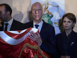 Conservative academic Kais Saied, center, flanked by his wife Ichraf Chebil, right, celebrates his victory in the Tunisian presidential election in the capital Tunis on October 13, 2019. (Fethi Belaid/AFP)