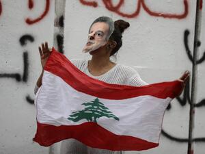 A Lebanese anti-government protester hold a mask of Lebanon's Central Bank Governor Riad Salameh during a protest in front of the central bank headquarters in Beirut to protest against the economic policies of the bank on November 27, 2019. (AFP/ File Photo)