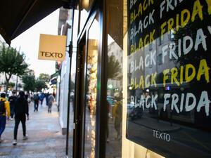 People walk past a showcase with a "Black Friday" logo on a banner in Ajaccio, on the French Mediterranean island of Corsica, on November 29, 2019 . PASCAL POCHARD-CASABIANCA / AFP