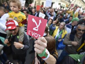 An Algerian demonstrator raises a red card that reads "No" in Arabic, referring to the upcoming presidential elections, during a rally in the capital Algiers on December 6, 2019. RYAD KRAMDI / AFP
