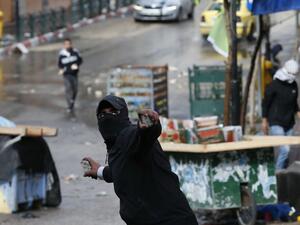 A Palestinian protester hurls stones during clashes with Israeli security forces in the southern West Bank city of Hebron, on December 9, 2019, amid a general strike over Israeli settlement activity. AFP