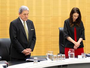 New Zealand Prime Minister Jacinda Ardern (C) and Deputy Prime Minister Winston Peters stand with cabinet ministers as they observe a minute's silence in respect for victims of the December 9 White Island volcanic eruption, at Parliament in Wellington on December 16, 2019. (AFP/ File Photo)