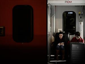 Travellers waiting for departure sit between two coaches at the Gare de Lyon railway station in Paris on December 20, 2019, on the 16th day of a nationwide multi-sector strike against the government's pensions overhaul. Philippe LOPEZ / AFP