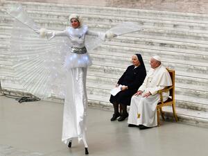 Pope Francis and Suor Antonietta Collacchi, director of the Santa Marta dispensary, look at a performer on stilts during an audience for children and families of the Santa Marta dispensary on December 22, 2019 at Paul-VI hall in the Vatican. Vincenzo PINTO / AFP
