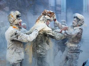Revellers dressed in mock military garb cover themselves in flour as they take part in the "Els Enfarinats" battle in the southeastern Spanish town of Ibi on December 28, 2019. During this 200-year-old traditional festival participants known as Els Enfarinats (those covered in flour) dress in military clothes and stage a mock coup d'etat as they battle using flour, eggs and firecrackers outside the city town hall as part of the celebrations of the Day of the Innocents, a traditional day in Spain for pulling