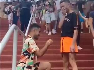 Two men kiss on the steps below a Ferris wheel before one man pulls out a ring (dailymail)