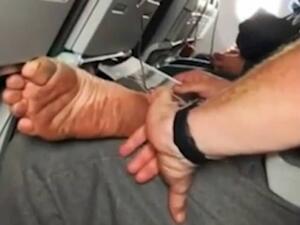 He is using the little finger of his left hand to scrape the thin layer of muck off the side of his heel. (Video Screenshot)
