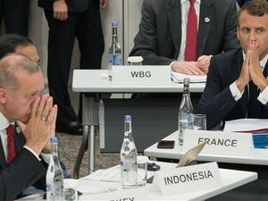 Turkey's President Recep Tayyip Erdogan (L) and his French counterpart Emmanuel Macron gesture as they attend a meeting on the digital economy at the G20 Summit in Osaka, Japan, June 28, 2019. (Photo by AFP)