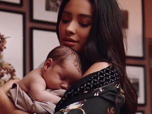 Shay had her daughter bundled up in a cozy white blanket as her little one rested in her mother's arms.