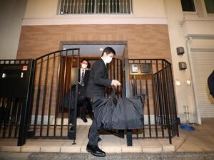 Japanese prosecutors carry bags as they leave the residence of former auto tycoon Carlos Ghosn on January 2, 2020, after Ghosn fled Japan to avoid a trial. Former Nissan boss Carlos Ghosn, who fled to Lebanon to avoid a Japanese trial, had a second French passport, a source said on January 2, as authorities raided his Tokyo residence as part of a probe into the embarrassing security lapse. STR / JIJI PRESS / AFP