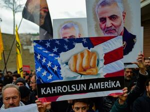 A protester holds a banner reading " down with America", during a demonstration outside the US consulate in Istanbul, on January 5, 2020, two days after top Iranian commander Qasem Soleimani was killed by a US drone strike. A US drone strike killed top Iranian commander Qasem Soleimani at Baghdad's international airport on January 3, dramatically heightening regional tensions and prompting arch enemy Tehran to vow "revenge". Yasin AKGUL / AFP
