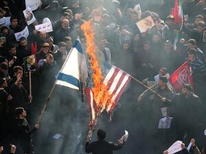 Iranians set a US and an Israeli flag on fire during a funeral procession organised to mourn the slain military commander Qasem Soleimani, Iraqi paramilitary chief Abu Mahdi al-Muhandis and other victims of a US attack in the capital Tehran on January 6, 2020. (AFP/ File Photo)